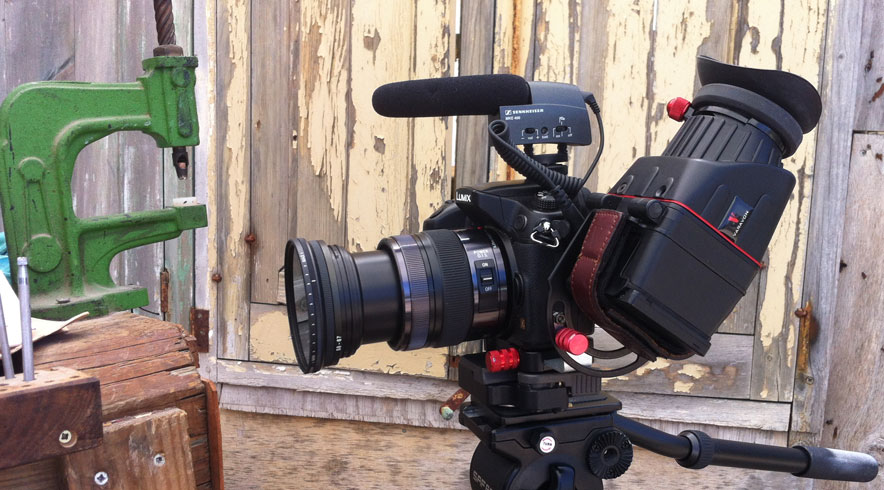 Quality video production. Photo of GH3 camera with Varavon loupe, variable ND filter and Sennheiser on-camera microphone during filming in Ibiza. Pictured next to a green G-clamp.