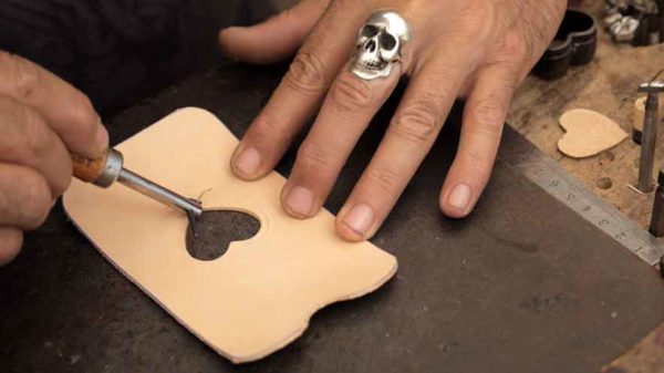 Artisan promotional video. A heart shape is cut from the centre of a mobile phone shaped piece of leather