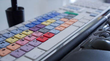 Photograph showing the coloured keys of my Logic keyboard, tablet pen and roller mouse pro.