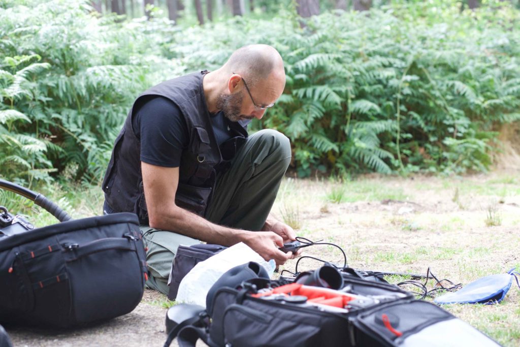 Video editing production quote showing Julian kneeling adjusting the settings of his radio microphones