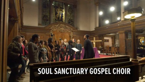 Web video production. Wide shot of the choir performing with the pews in the foreground