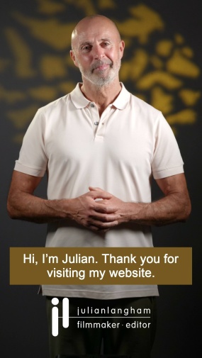 Upper 75% of Julian's body is wearing a cream polo shirt standing speaking to camera in front of gold patterned background with white subtitles over a gold background