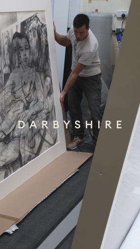 Darbyshire workshop promo Instagram version showing man holding the edge of a large monochrome artwork drawing frame