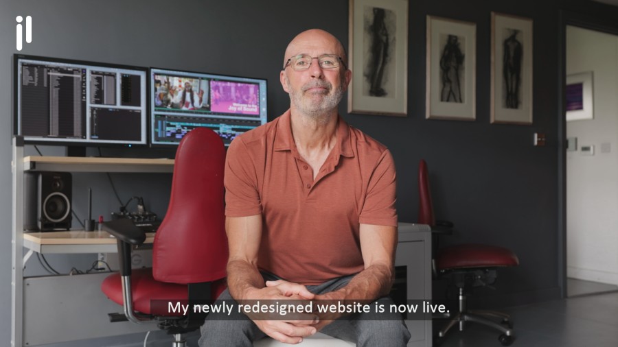 Professional talking-head video production showing Julian sitting at his editing workstation.