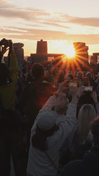 Stonehenge solstice 2026 sunrise showing stones and people watching