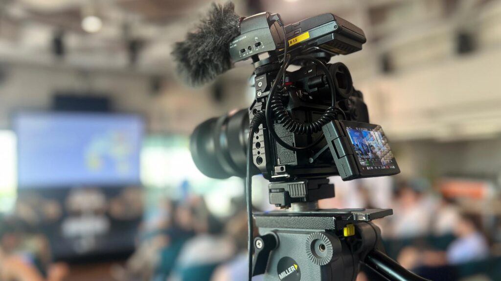 Fast turnaround social media video production showing a camera fitted with a radio mic on a tripod filming.
